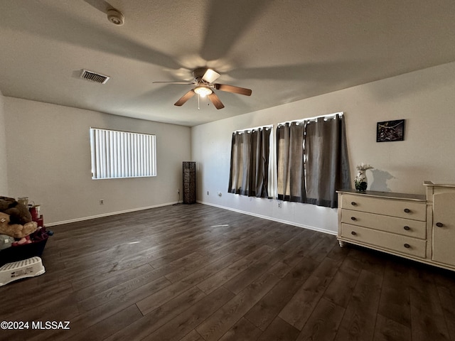 unfurnished bedroom featuring dark hardwood / wood-style flooring, a textured ceiling, and ceiling fan