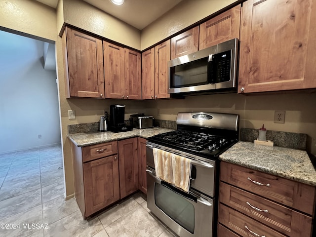 kitchen featuring stainless steel appliances and light stone countertops