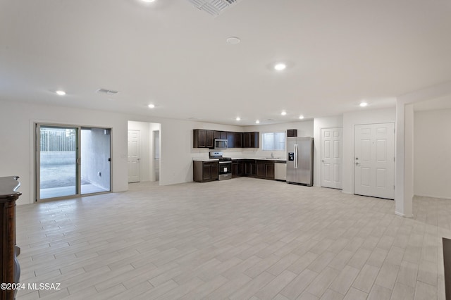 unfurnished living room featuring light wood-type flooring and sink