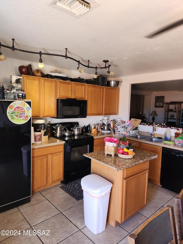 kitchen featuring sink, a kitchen island, black appliances, and light tile patterned floors