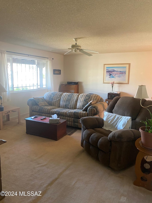 carpeted living room with a textured ceiling and ceiling fan