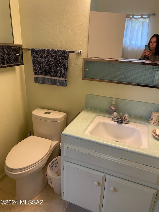 bathroom featuring tile patterned flooring, vanity, and toilet