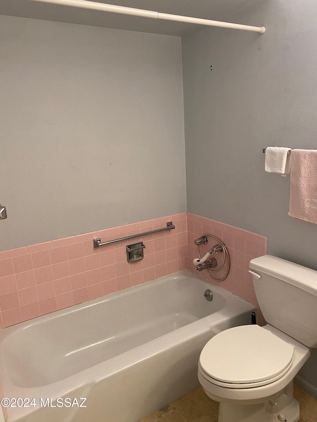 bathroom with a tub, tile patterned flooring, and toilet