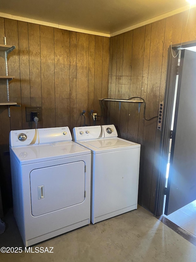 laundry room featuring laundry area, separate washer and dryer, and wood walls