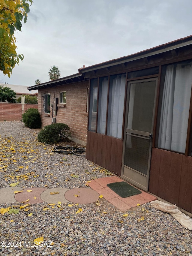 view of home's exterior featuring brick siding and fence