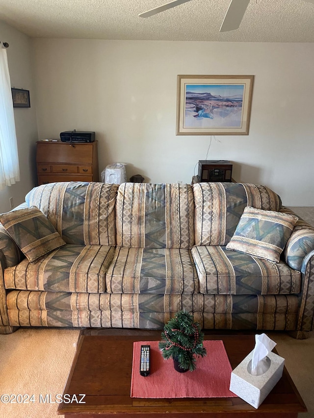 carpeted living room with ceiling fan and a textured ceiling