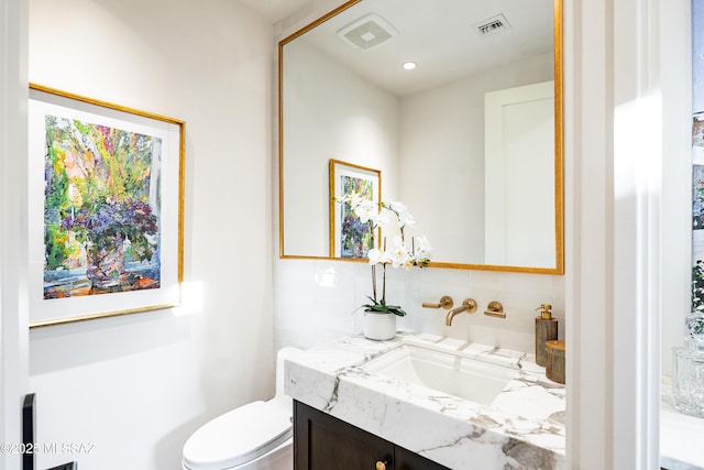 5200 N Camino Antonio, Tucson, AZ 85718 - half bathroom featuring toilet, visible vents, vanity, and tasteful backsplash