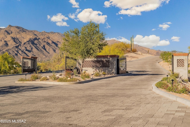 5200 N Camino Antonio, Tucson, AZ 85718 - view of road featuring a mountain view, curbs, a gated entry, and a gate