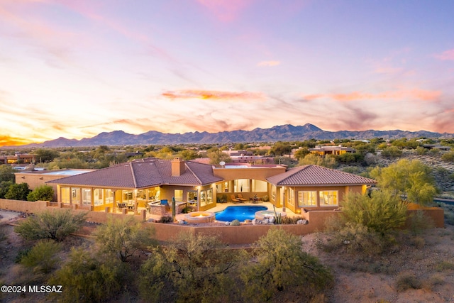 back house at dusk featuring a patio area and a mountain view