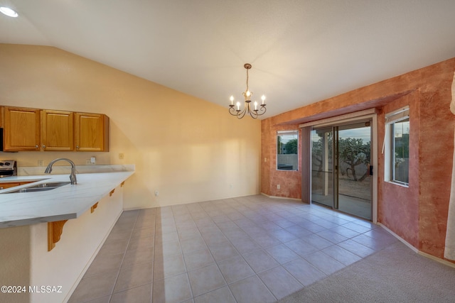 kitchen featuring hanging light fixtures, an inviting chandelier, lofted ceiling, a breakfast bar area, and light tile patterned flooring