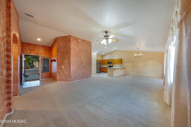 unfurnished living room featuring ceiling fan with notable chandelier, lofted ceiling, and light carpet