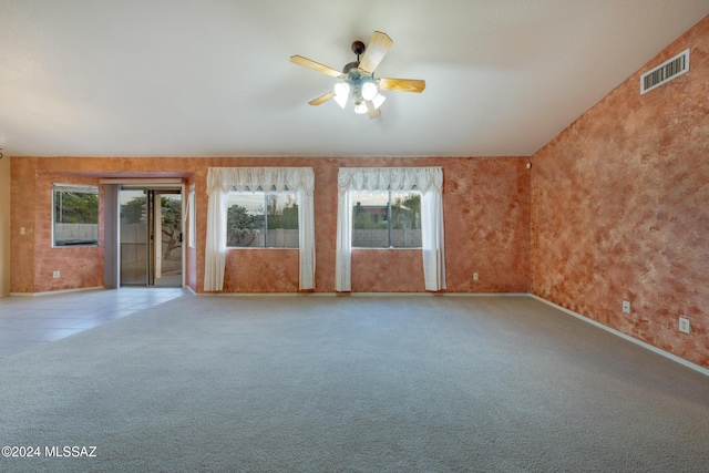 unfurnished living room featuring vaulted ceiling, ceiling fan, and a healthy amount of sunlight