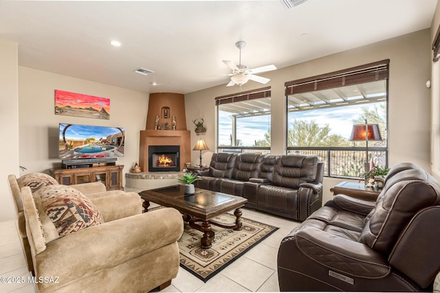 living room with light tile patterned floors, a fireplace, and ceiling fan