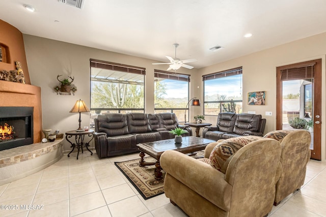 living room with a fireplace, ceiling fan, and light tile patterned flooring