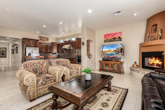 living room with light tile patterned flooring and a fireplace