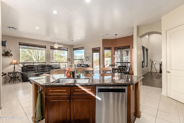 kitchen featuring light tile patterned flooring, sink, an island with sink, and hanging light fixtures