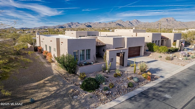 pueblo-style home with a mountain view and a garage