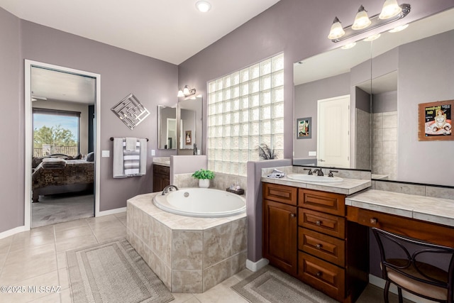 bathroom with vanity, tile patterned floors, and tiled bath