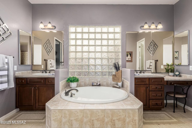 bathroom featuring tile patterned flooring, vanity, and tiled bath