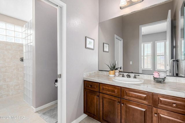 bathroom featuring plenty of natural light, tile patterned flooring, vanity, and a shower