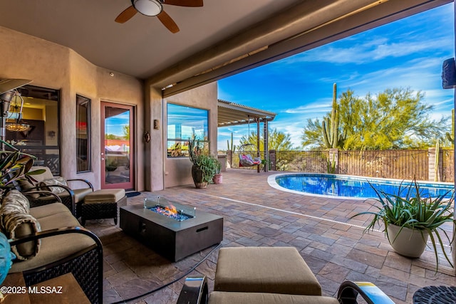 view of patio with ceiling fan, a fenced in pool, and a fire pit