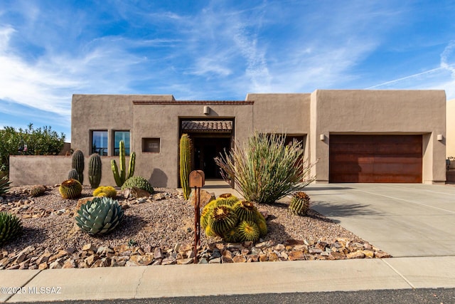 pueblo-style house featuring a garage