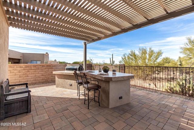 view of patio / terrace featuring exterior bar, area for grilling, and a pergola