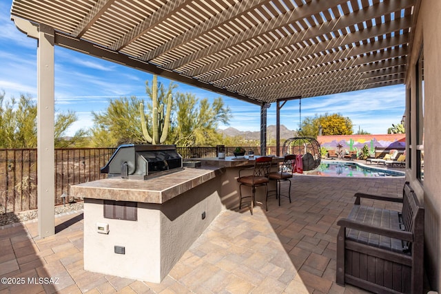 view of patio with an outdoor kitchen, area for grilling, a pergola, a bar, and a fenced in pool