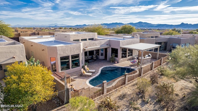 back of property with a mountain view and a patio area