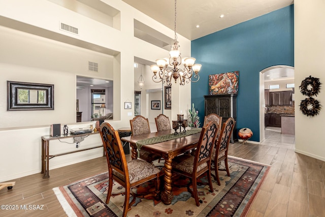 dining room with a high ceiling and a notable chandelier