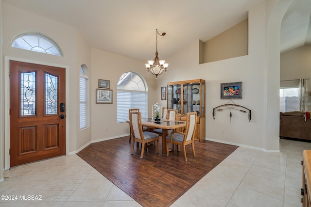 dining space featuring an inviting chandelier, light hardwood / wood-style floors, and vaulted ceiling