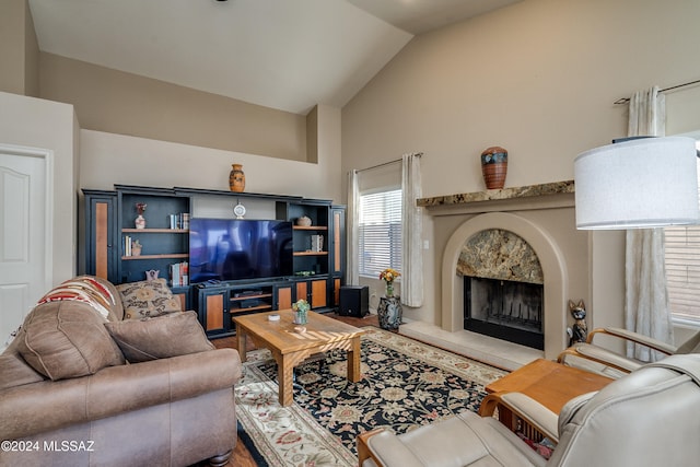 living room with a high end fireplace and lofted ceiling