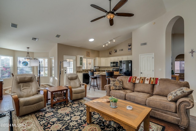 living room featuring light hardwood / wood-style floors, high vaulted ceiling, and ceiling fan