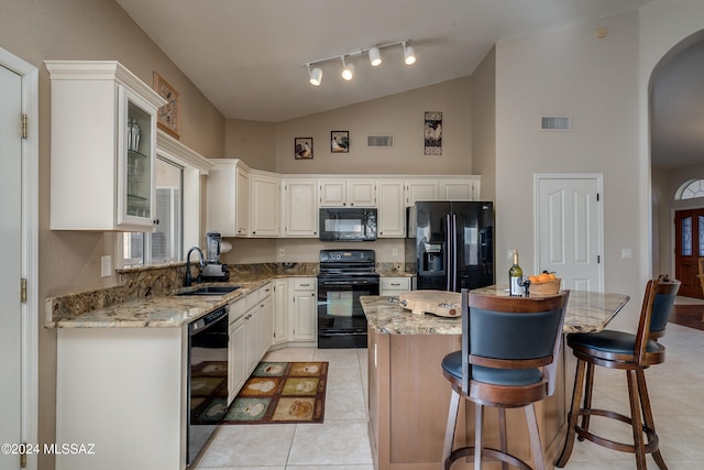 kitchen featuring sink, a kitchen island, lofted ceiling, white cabinets, and black appliances