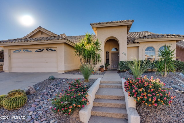 mediterranean / spanish-style home with a garage