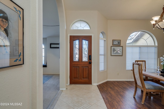 foyer entrance with a chandelier, plenty of natural light, and light hardwood / wood-style floors