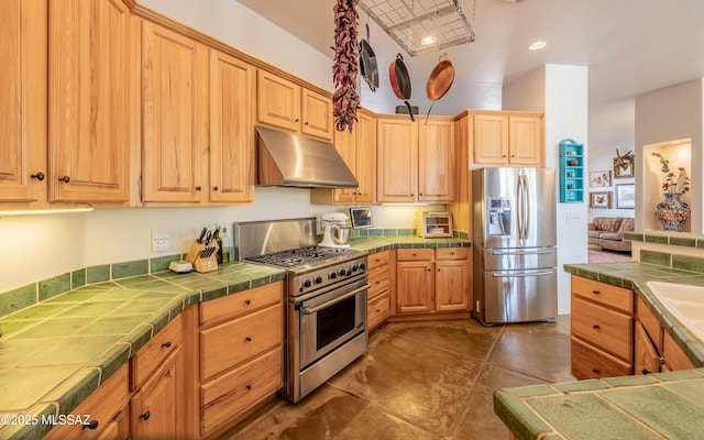 kitchen featuring a toaster, under cabinet range hood, stainless steel appliances, tile counters, and light brown cabinetry