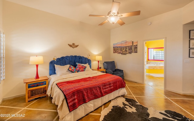 tiled bedroom with ensuite bathroom, ceiling fan, and baseboards