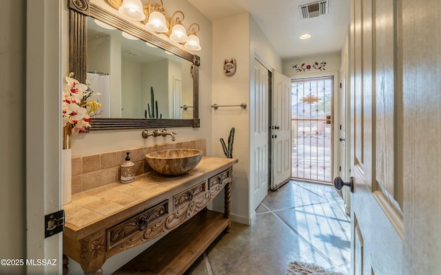 full bath with concrete flooring, visible vents, vanity, and baseboards