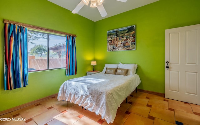 bedroom with a ceiling fan, tile patterned flooring, and baseboards