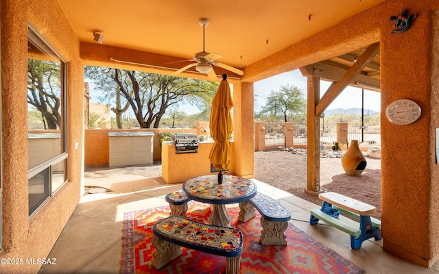 view of patio with ceiling fan, fence, and a mountain view