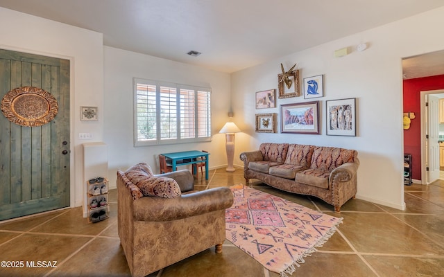 tiled living room with visible vents and baseboards