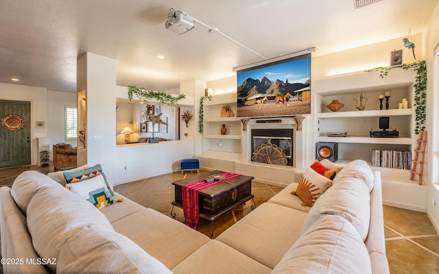 living room with built in shelves, recessed lighting, a glass covered fireplace, baseboards, and tile patterned floors