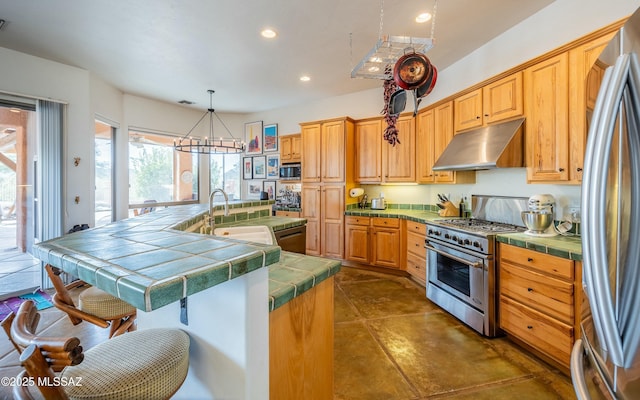 kitchen with appliances with stainless steel finishes, recessed lighting, under cabinet range hood, and tile countertops