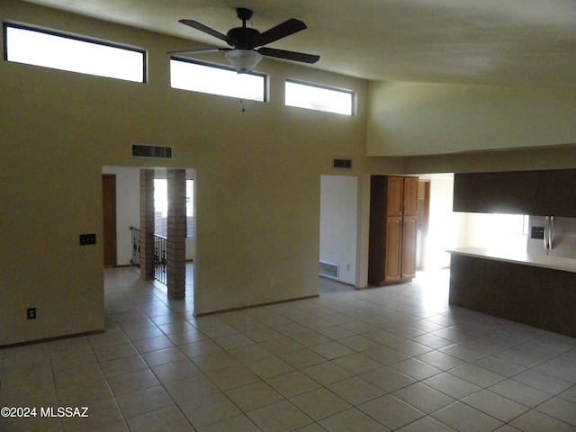 tiled spare room featuring a wealth of natural light and ceiling fan