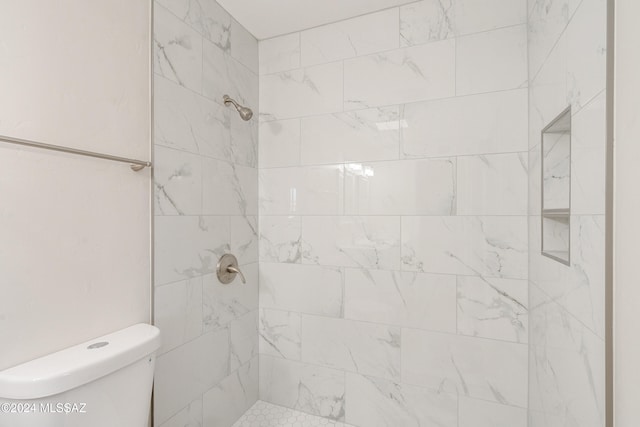 bathroom with toilet and a tile shower