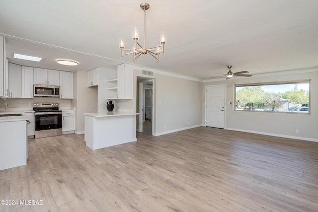 kitchen with stainless steel appliances, pendant lighting, white cabinets, and light hardwood / wood-style floors