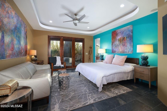 bedroom with a raised ceiling, access to exterior, and ceiling fan