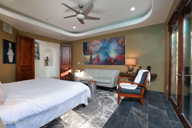 bedroom with a tray ceiling and ceiling fan