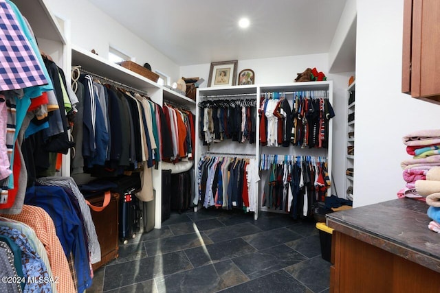 walk in closet with stone finish floor